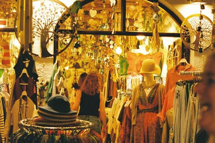 Inside a clothing boutique, with racks, a mannequin, and shoppers