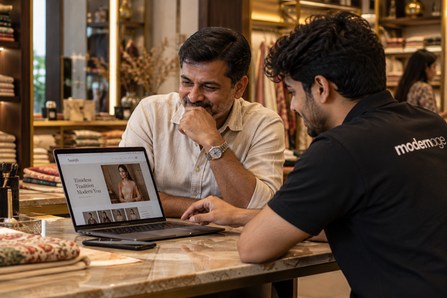 A boutique owner and a Modern Age teammate reviewing a clothing website together